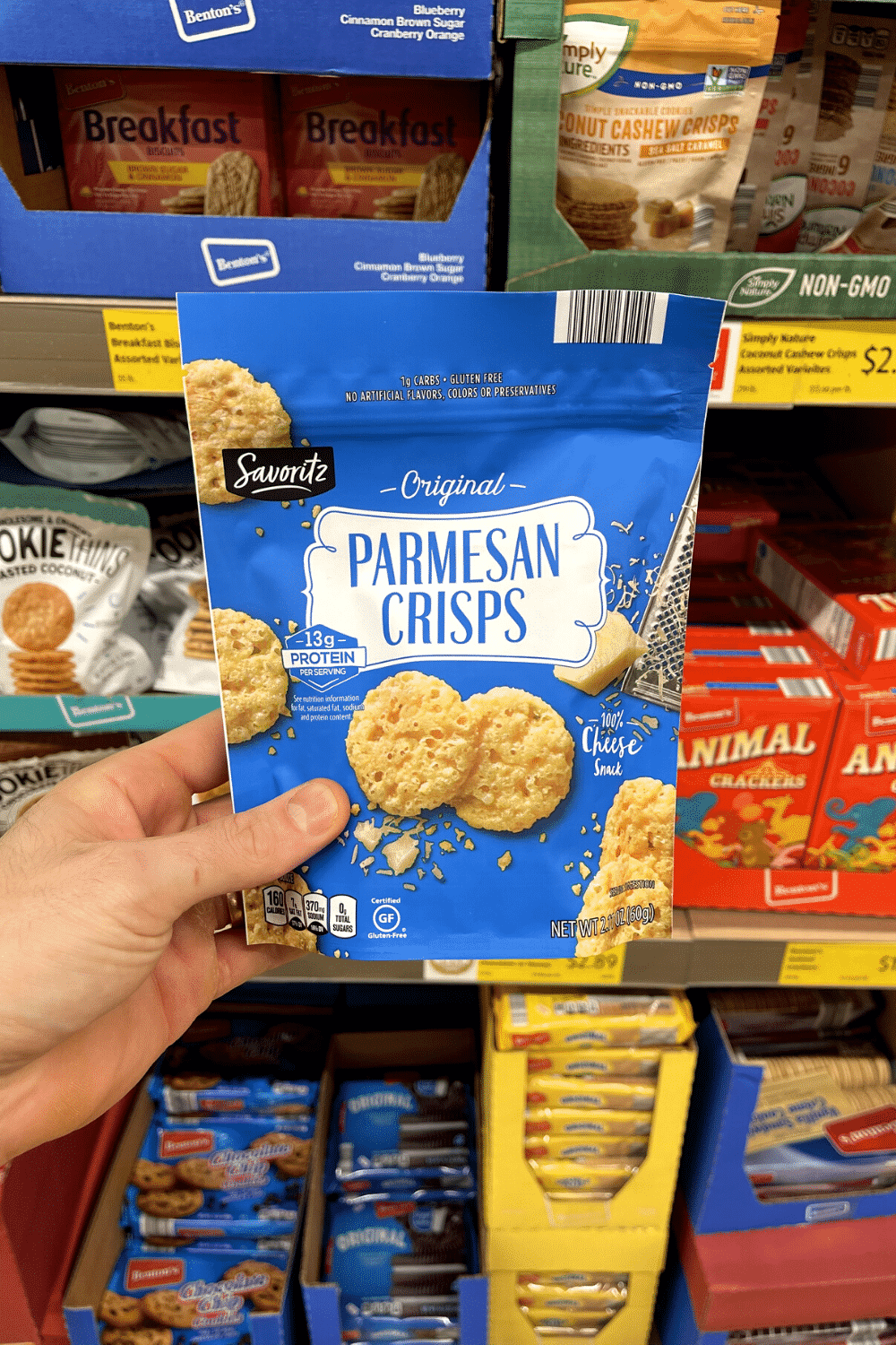 A hand holding a bag of parm crisps.