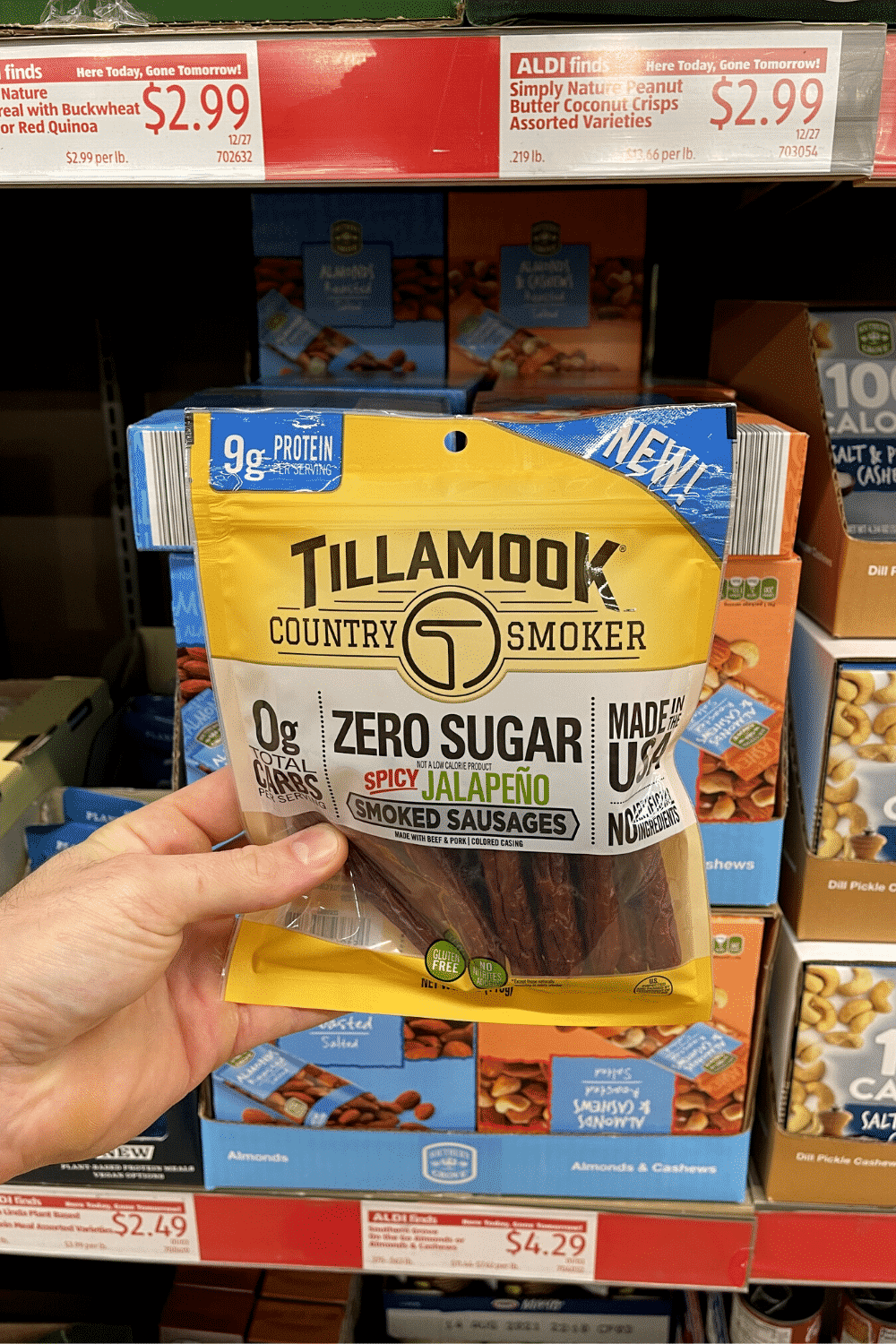 A hand holding a bag of smoked sausages