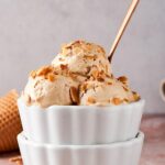 Three scoops of almond ice cream in a white bowl.