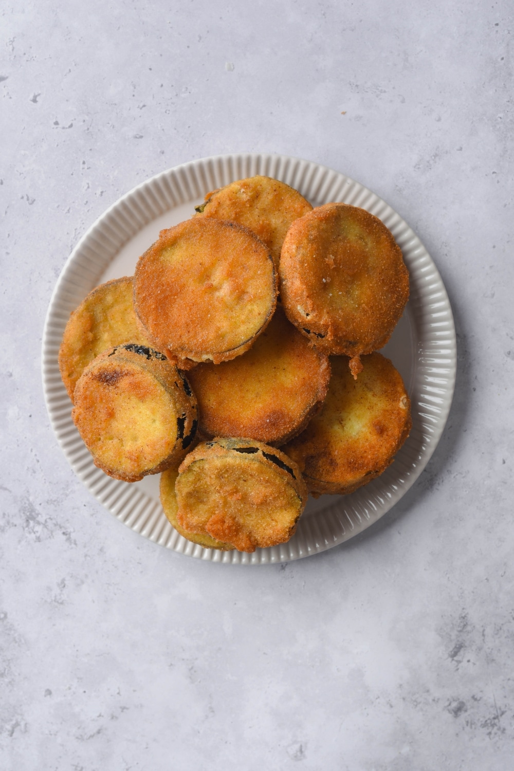 Fried eggplant slices on a white plate.
