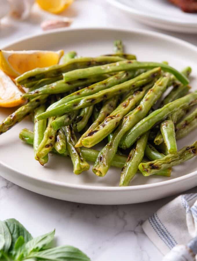 Grilled greens stacked on top of one another on a white plate.