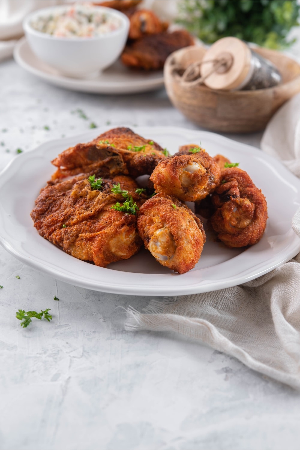 A plate of baked chicken legs and thighs garnished with parsley.