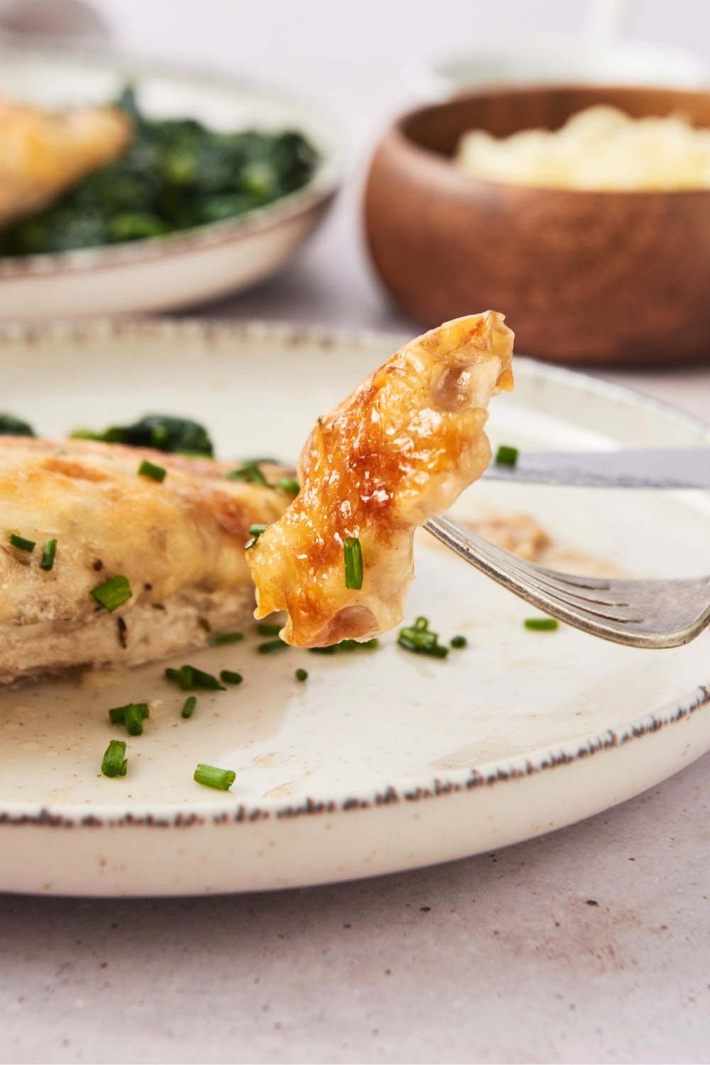 A fork with a piece of chicken on it.