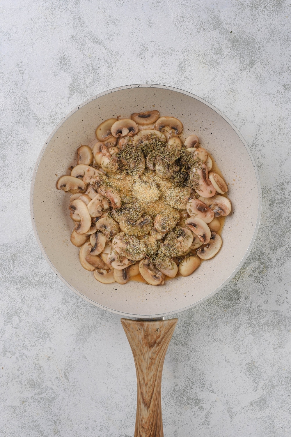 Cooked mushrooms coated in flour and seasonings in a white sauce pan.