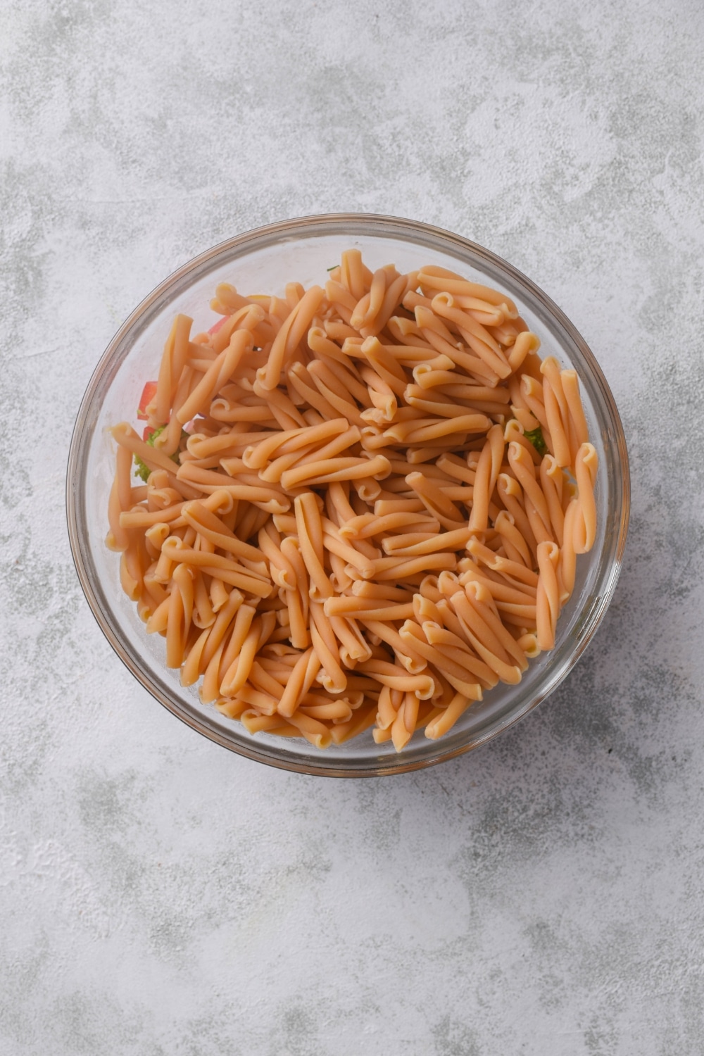 A clear bowl filled with cooked pasta.