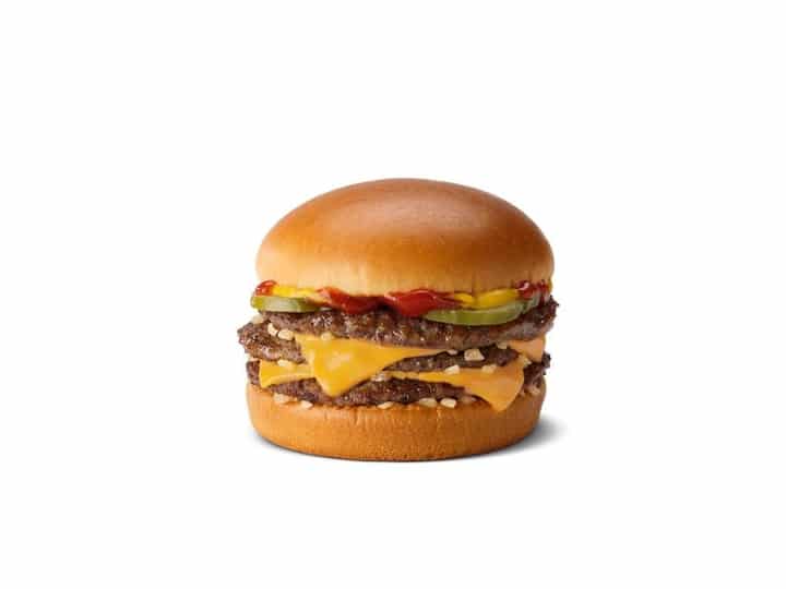 A triple cheeseburger with ketchup, pickles, and mustard.