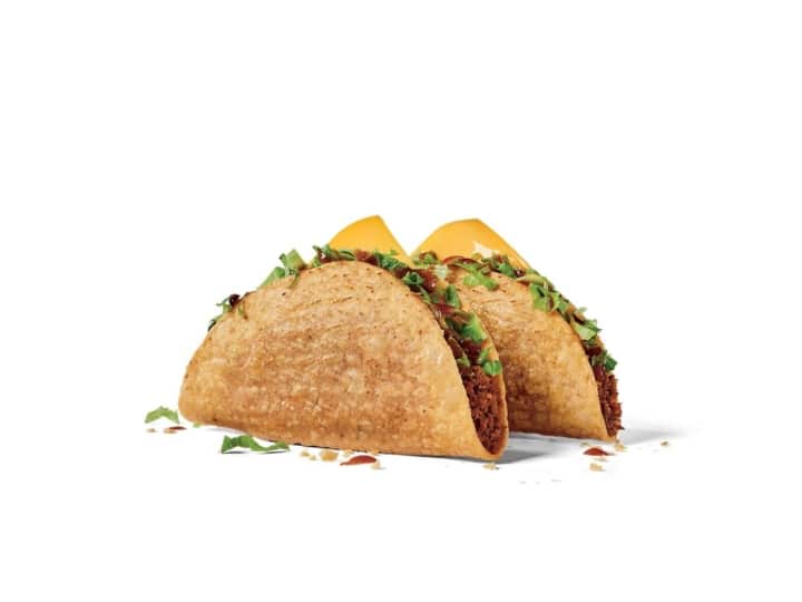 Two ground beef tacos with shredded lettuce.