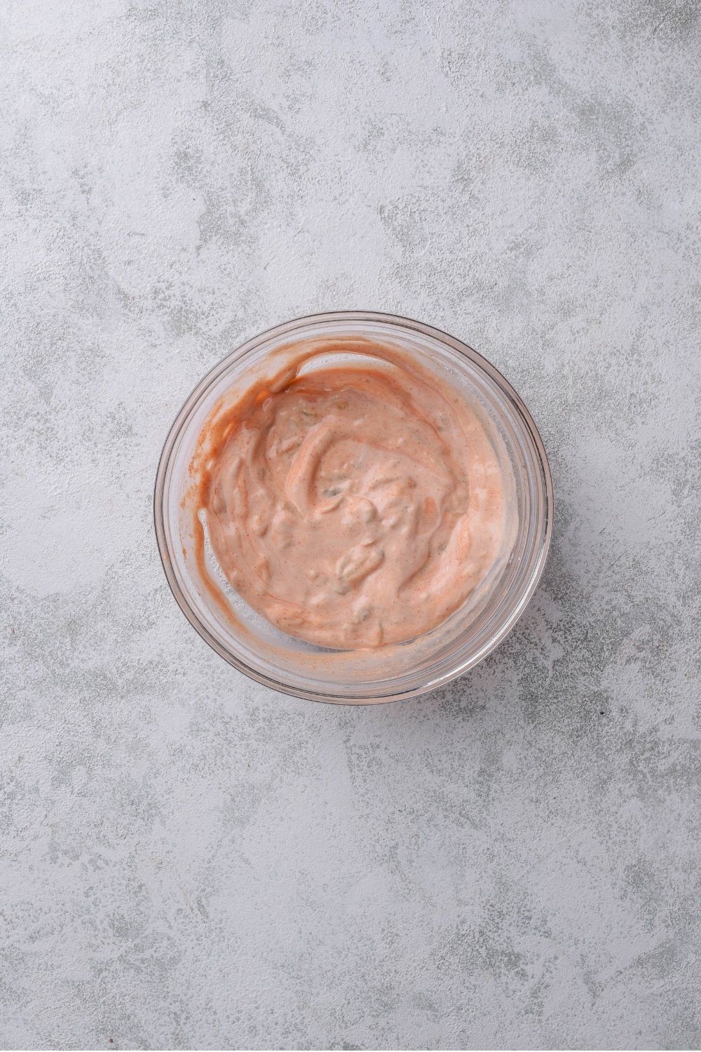 An overhead shot of a small glass bowl filled with a low calorie big mac sauce mixture.