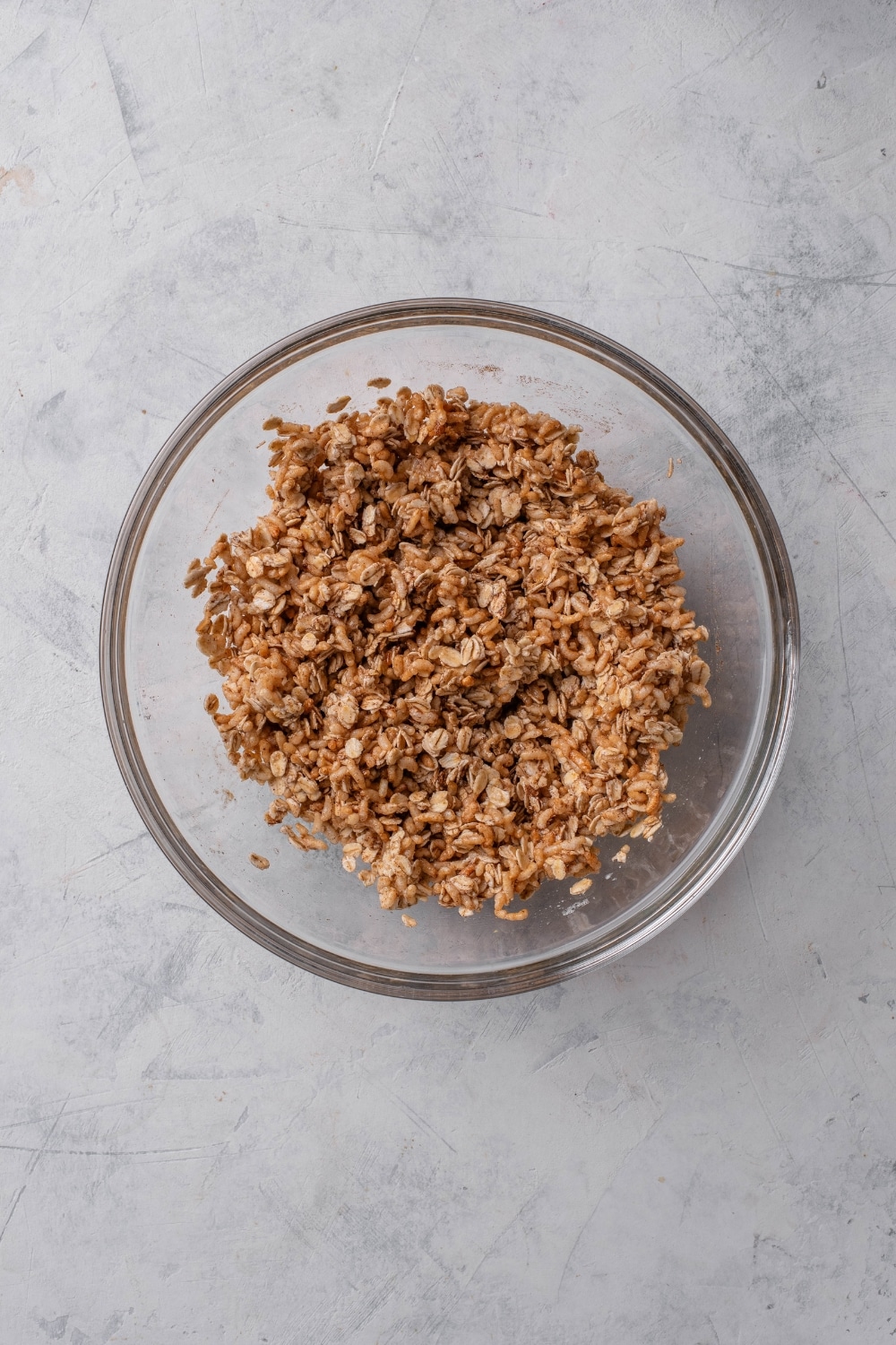 A clear bowl filled with unbaked granola.