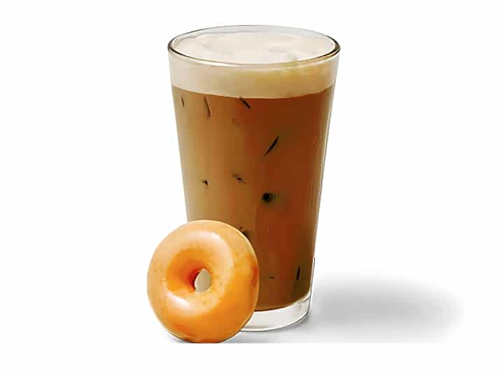 An image of an original iced glazed coffee from Krispy Kreme in a glass cup with a doughnut to the side on a white background.