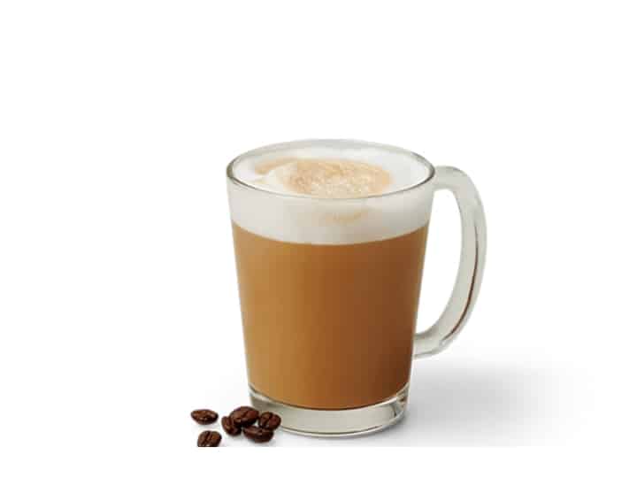 An image of espresso from Krispy Kreme in a glass mug with several espresso beans next to it An image of a vanilla iced coffee from Krispy Kreme on a white background.