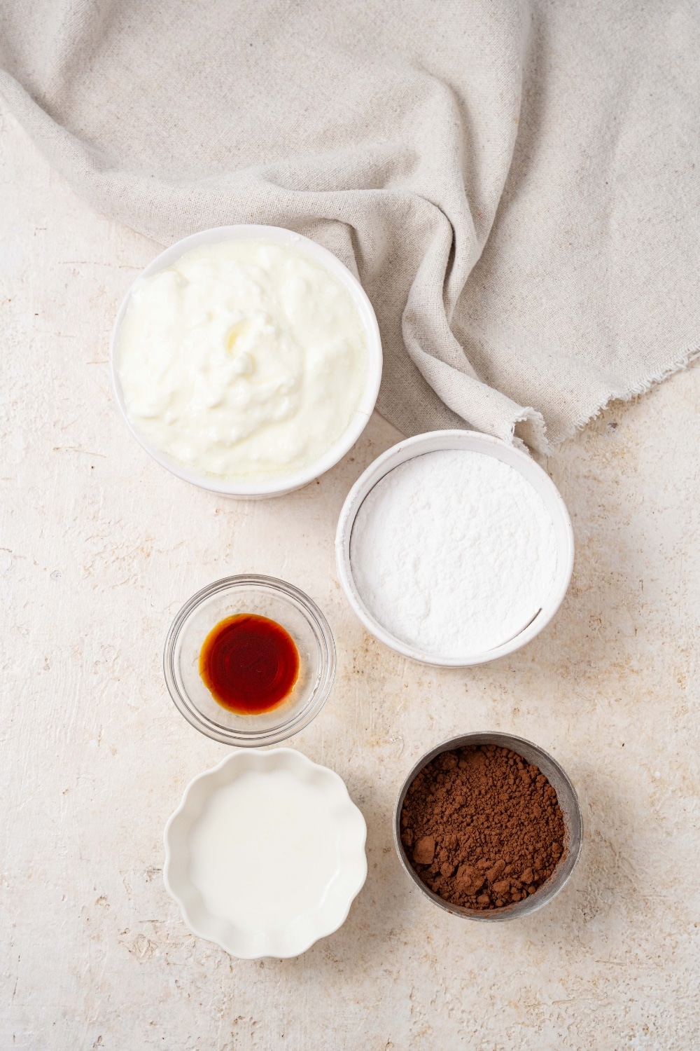 Bowls of cottage cheese, powdered allulose, vanilla extract, heavy cream, and cocoa powder.