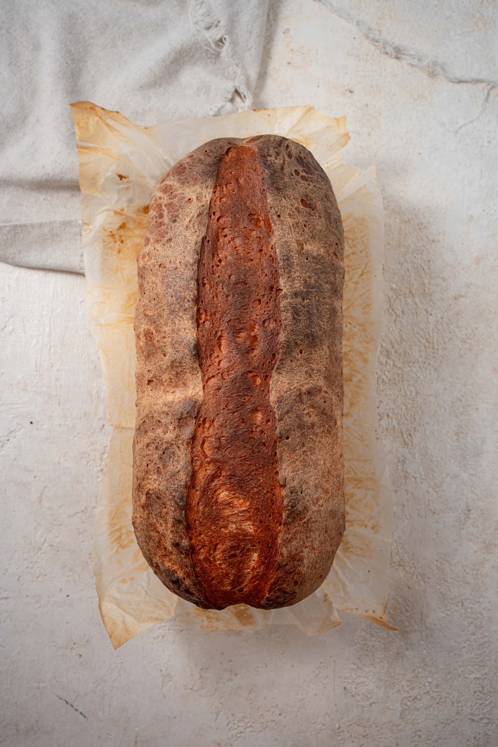 Top view of a cottage cheese bread loaf on parchment paper.