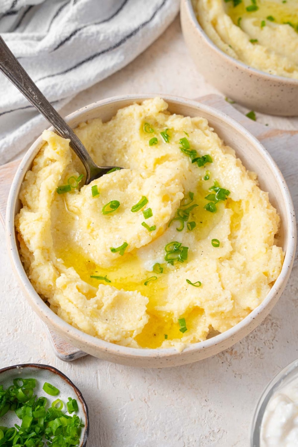 A spoon scooping into a bowl of cottage cheese mashed potatoes.