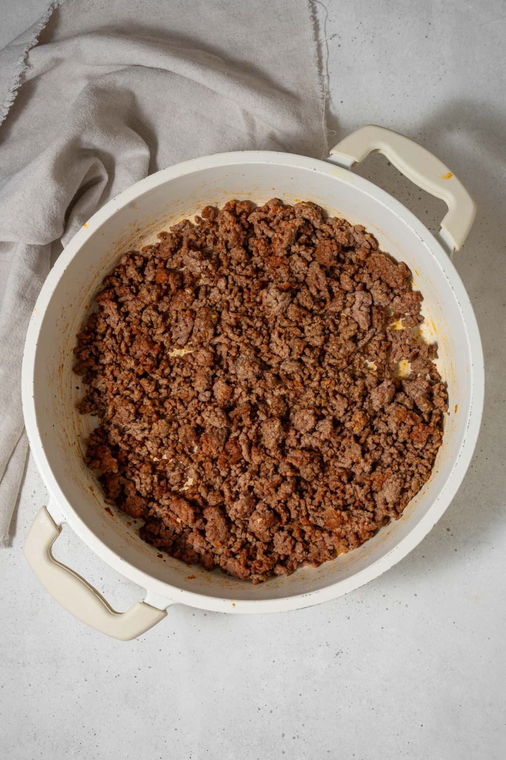 Seasoned ground beef in a white pot.
